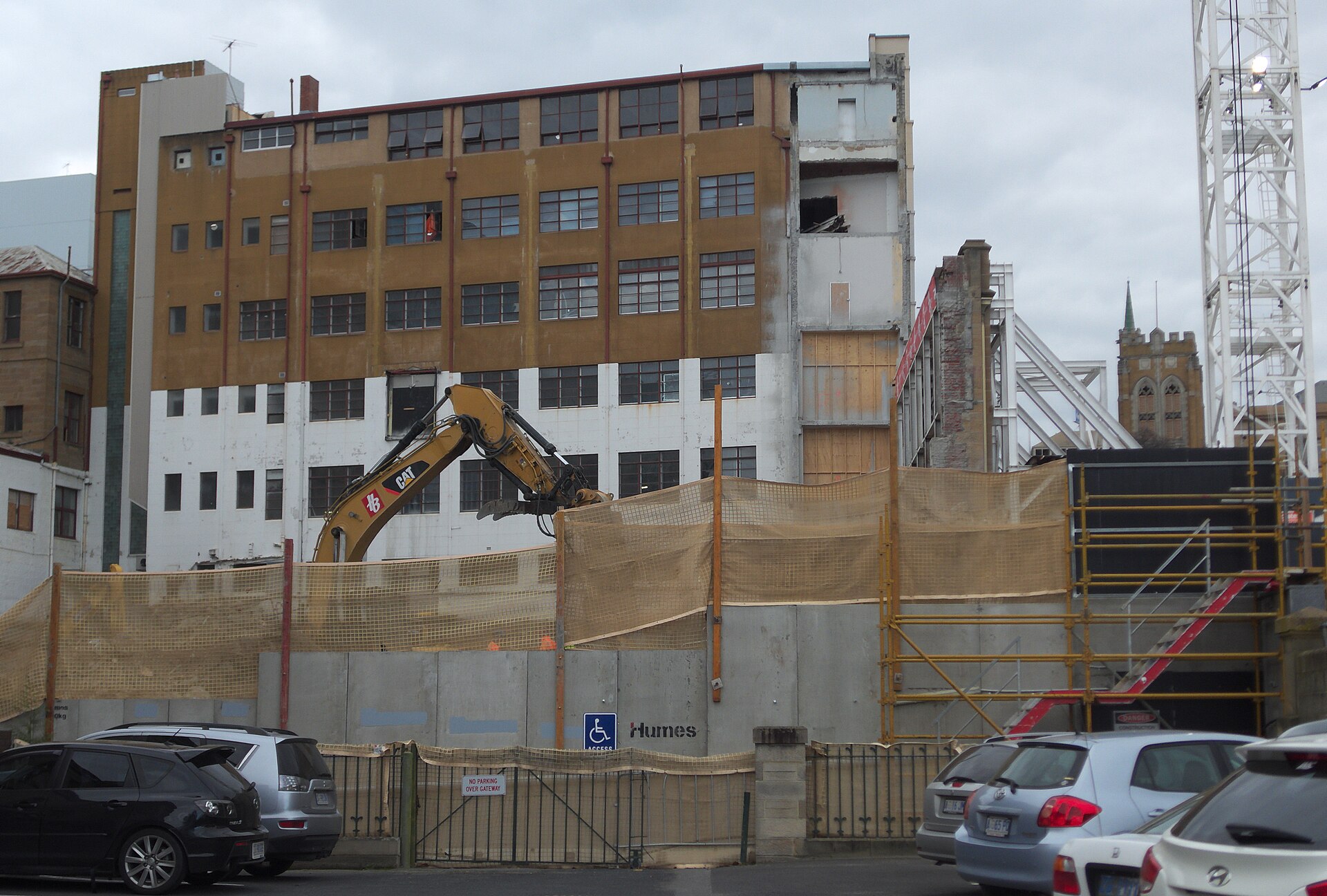 Commercial construction site with an excavator and site hoarding