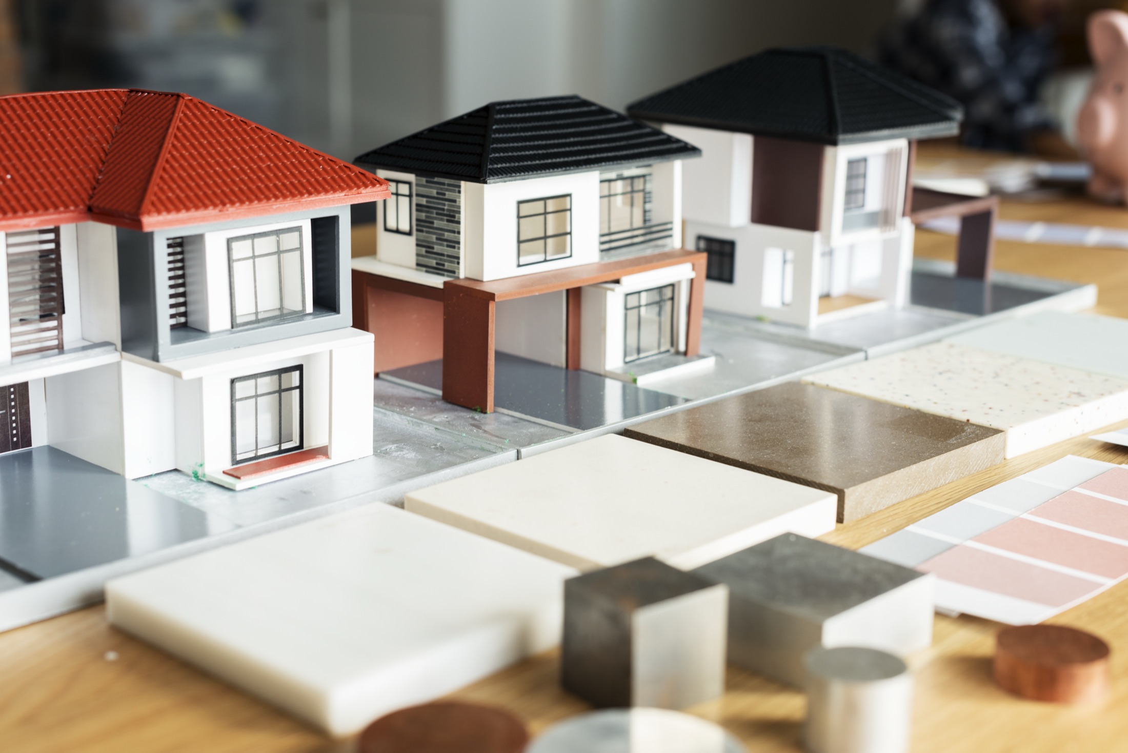 Architectural models beside material samples and colour swatches laid out on a bench.
